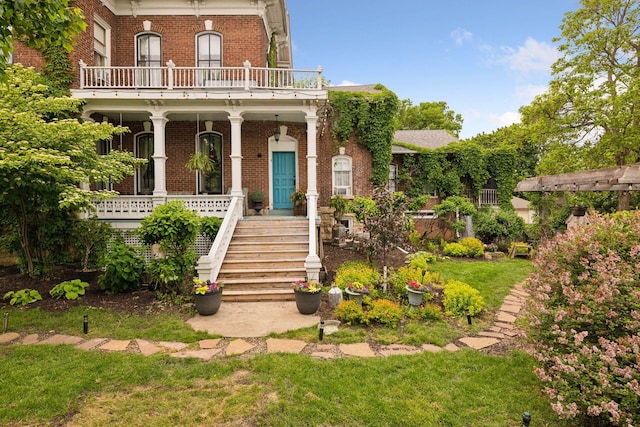 706 4th St, Red Wing, MN 55066 - italianate home with brick siding, a balcony, covered porch, and stairs