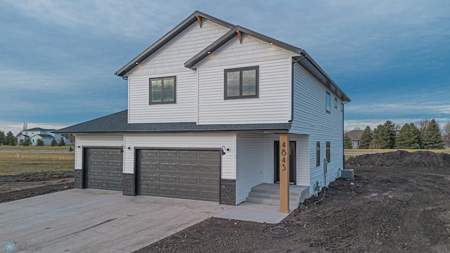 view of front of house featuring a garage and central air condition unit