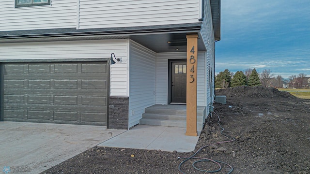 doorway to property with central AC unit and a garage