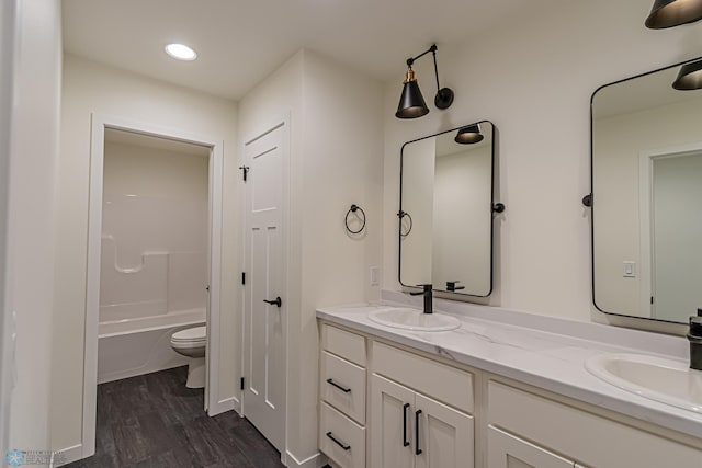 full bathroom featuring vanity, wood-type flooring, shower / bathtub combination, and toilet