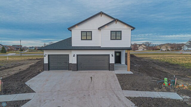 traditional-style home with an attached garage, driveway, and a residential view