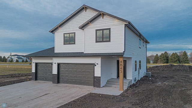 view of side of property with an attached garage, cooling unit, and concrete driveway