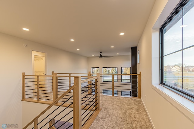 hallway with recessed lighting, baseboards, an upstairs landing, and carpet