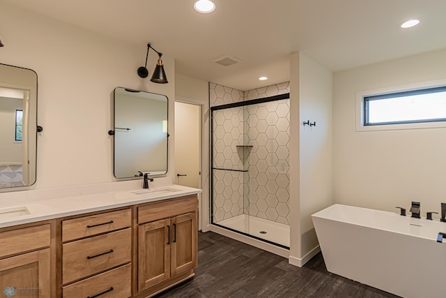 full bathroom with recessed lighting, a sink, wood finished floors, and a shower stall