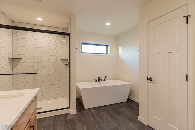 bathroom featuring recessed lighting, a shower stall, wood finished floors, and vanity