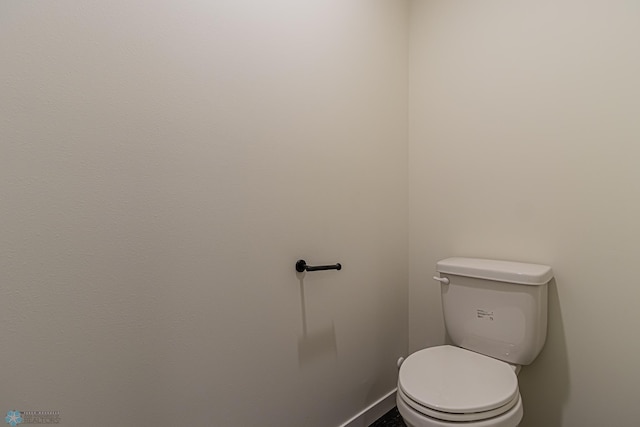 bathroom with toilet and baseboards