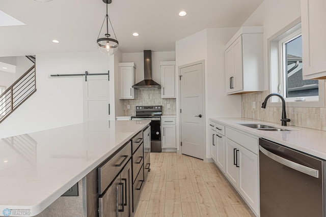 1264 Marlys Dr W, West Fargo, ND 58078 - kitchen with stainless steel appliances, wall chimney exhaust hood, a barn door, light stone counters, and decorative backsplash