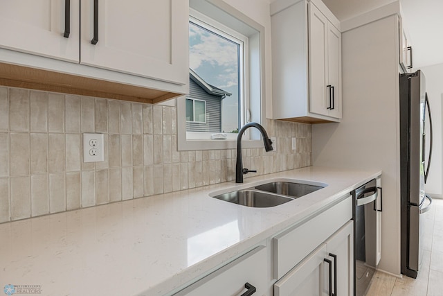 1264 Marlys Dr W, West Fargo, ND 58078 - kitchen featuring stainless steel appliances, light stone counters, tasteful backsplash, white cabinets, and light wood-style floors