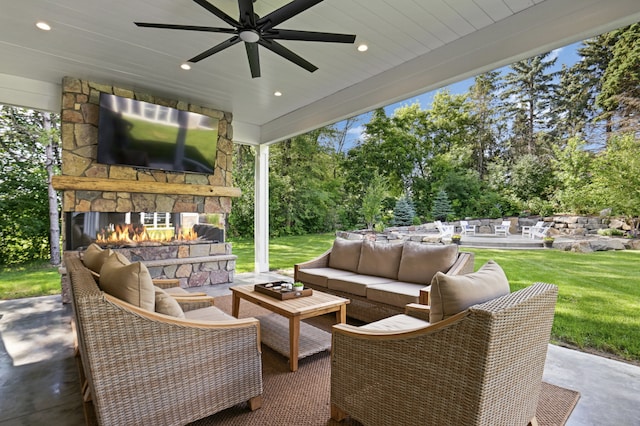 view of patio / terrace with ceiling fan and an outdoor living space with a fireplace