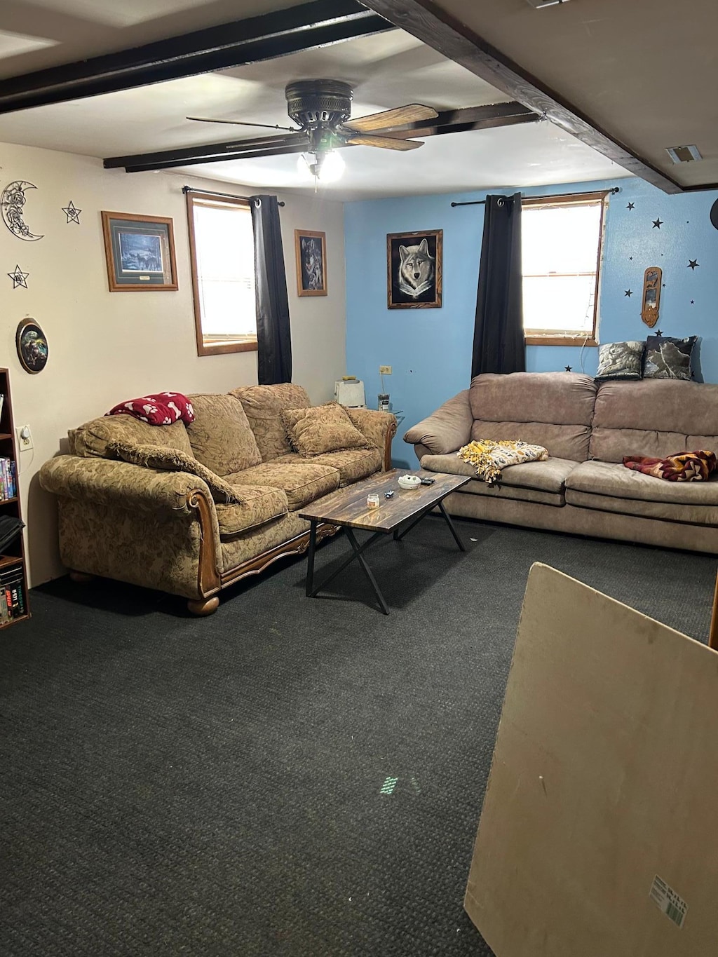 carpeted living room featuring ceiling fan and beamed ceiling