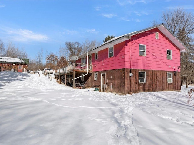 snow covered property with a wooden deck