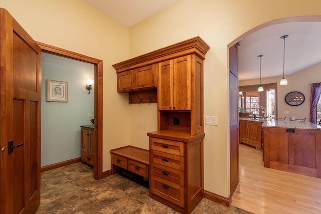 interior space featuring arched walkways, a sink, and baseboards