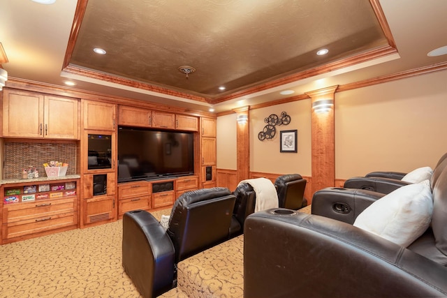 cinema room with a wainscoted wall, a tray ceiling, light colored carpet, and ornate columns