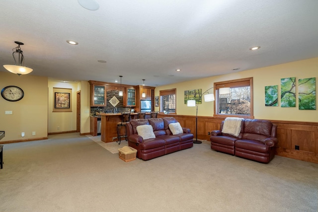 living area featuring recessed lighting, wainscoting, and light colored carpet