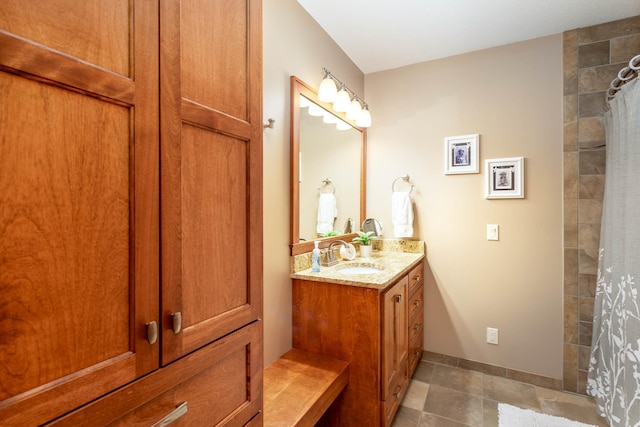 bathroom featuring a shower with shower curtain, tile patterned flooring, vanity, and baseboards