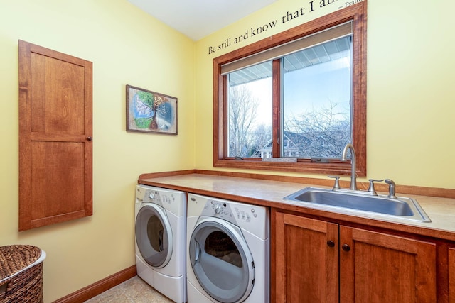 laundry room with cabinet space, baseboards, a sink, and independent washer and dryer