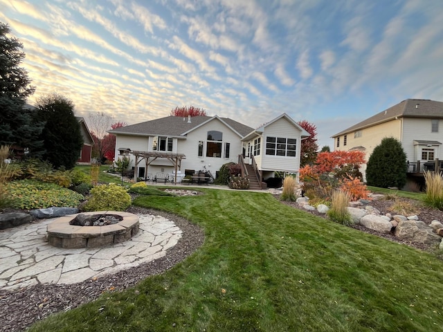 rear view of property with an outdoor fire pit, a lawn, a sunroom, stairs, and a pergola