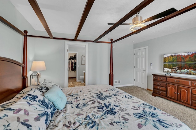 bedroom featuring ceiling fan, light colored carpet, and beam ceiling