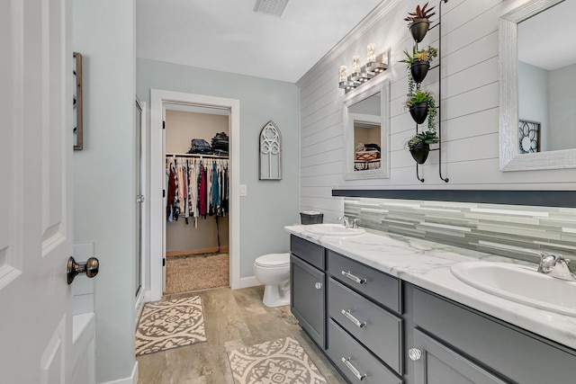 bathroom featuring hardwood / wood-style floors, vanity, a shower with shower door, toilet, and wood walls