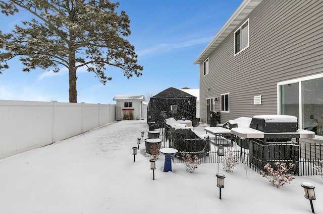 snow covered patio featuring a storage shed