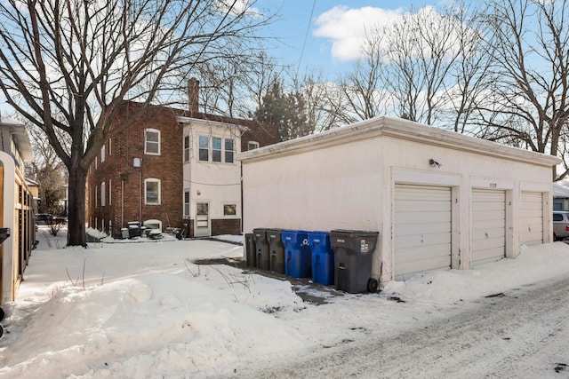 snow covered garage with a detached garage