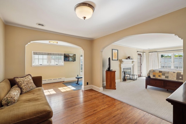 living room with crown molding, a baseboard radiator, and light hardwood / wood-style floors