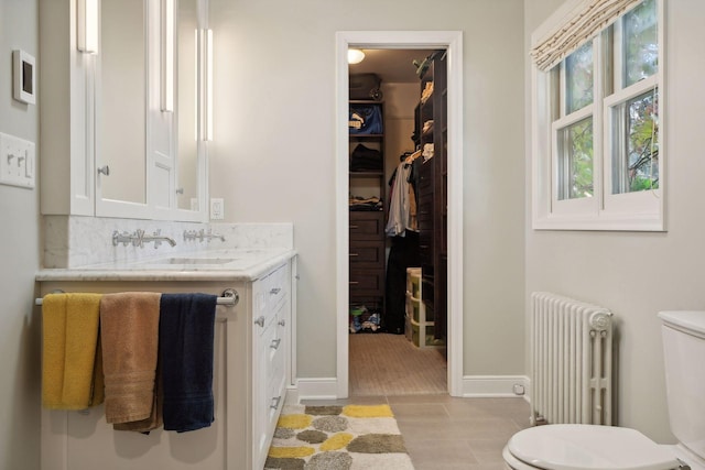 bathroom featuring vanity, radiator heating unit, tasteful backsplash, and toilet