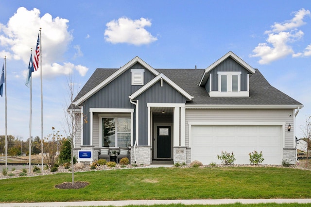 craftsman house featuring a garage and a front lawn