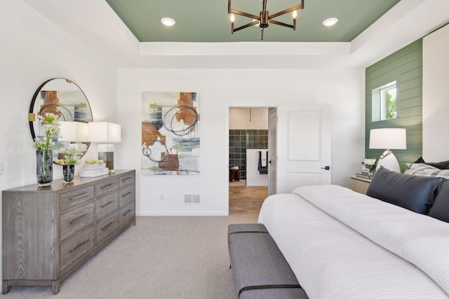 carpeted bedroom featuring a chandelier and a tray ceiling