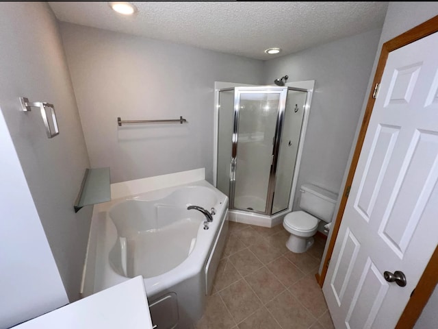 full bathroom with a garden tub, toilet, a stall shower, a textured ceiling, and tile patterned flooring