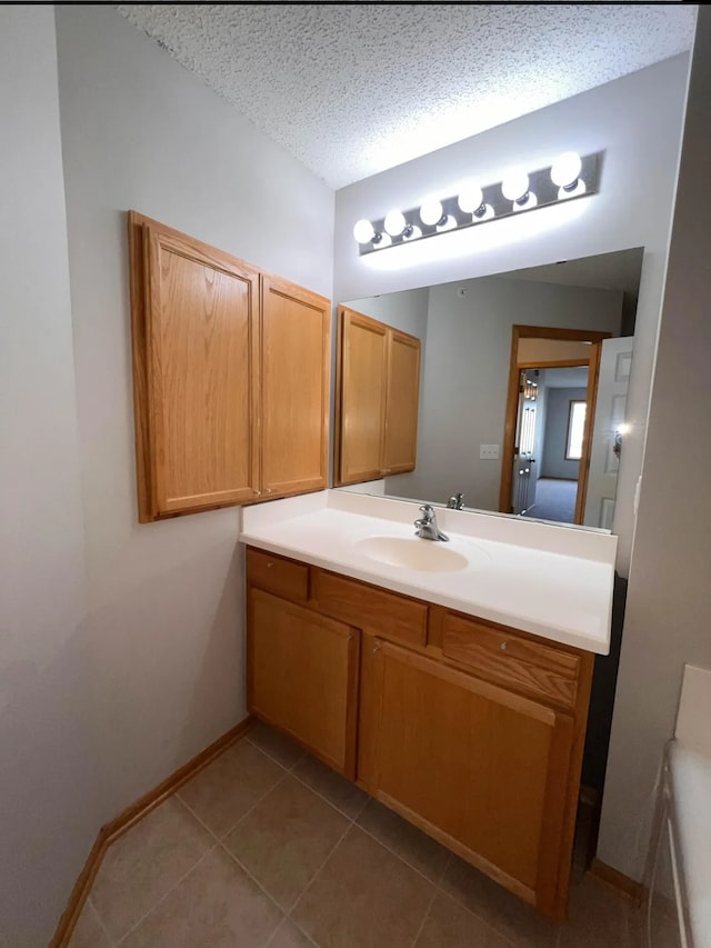 bathroom featuring tile patterned floors, a textured ceiling, vanity, and baseboards