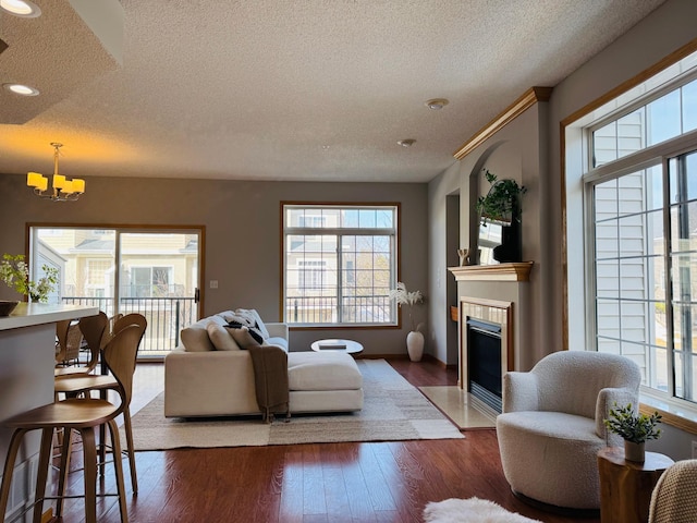 living room featuring wood finished floors, a healthy amount of sunlight, and a tile fireplace