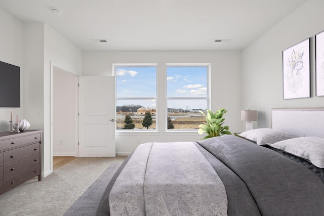 bedroom featuring light carpet, visible vents, and baseboards