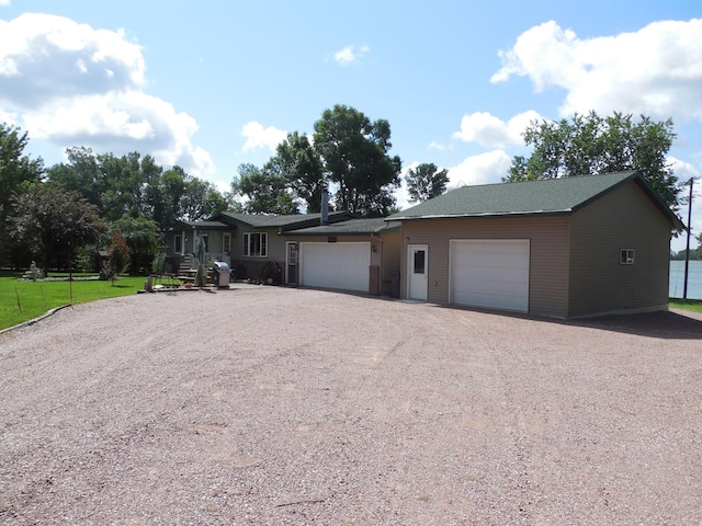 single story home featuring dirt driveway and a garage