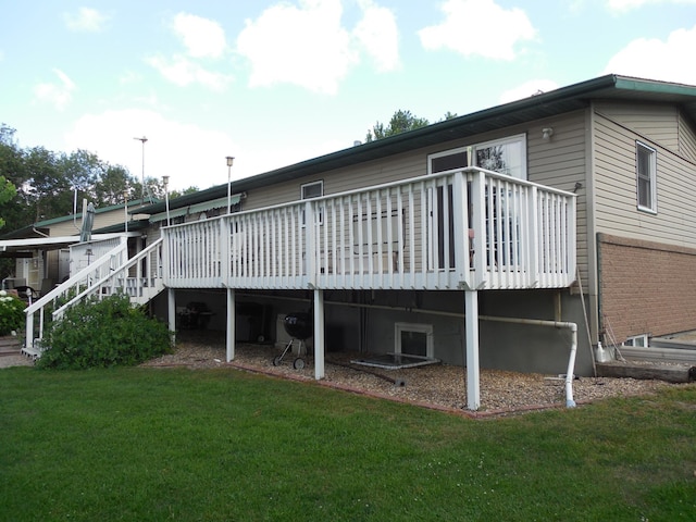 rear view of house featuring a lawn, a wooden deck, and stairway