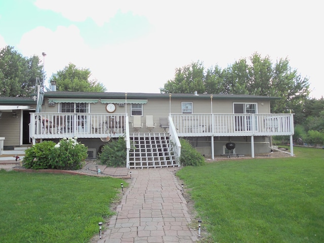 view of front of house with a front lawn, a deck, and stairs