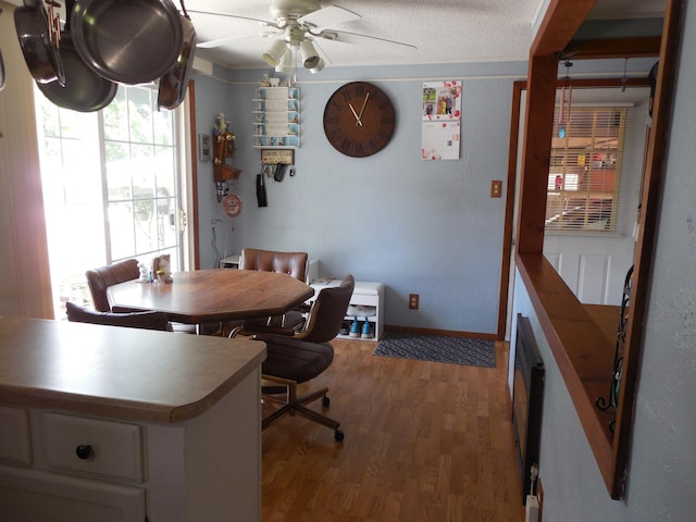 dining space with baseboards, wood finished floors, and ceiling fan