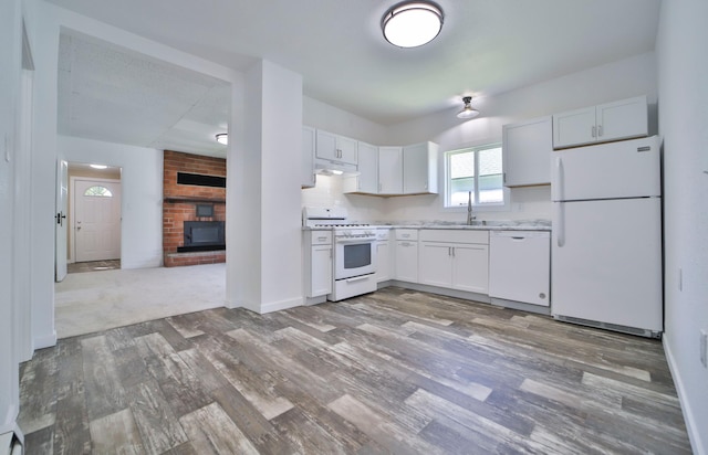 kitchen featuring sink, white cabinetry, tasteful backsplash, wood-type flooring, and white appliances