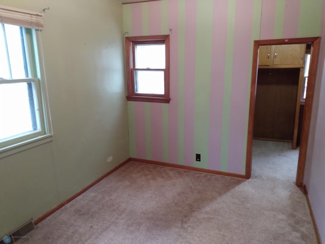 unfurnished room featuring light colored carpet