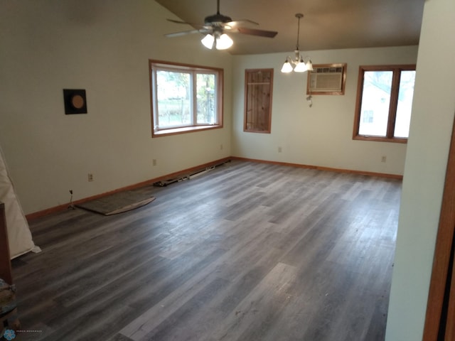 interior space featuring a wealth of natural light, dark hardwood / wood-style flooring, ceiling fan with notable chandelier, and an AC wall unit