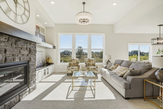 living room with a fireplace, light colored carpet, and a chandelier