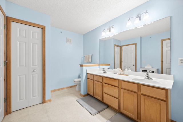 13905 52nd Ave N Unit 701, Plymouth, MN 55446 - bathroom featuring double vanity, a closet, and a textured ceiling