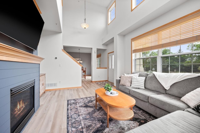 13905 52nd Ave N Unit 701, Plymouth, MN 55446 - living area with wood finished floors, a glass covered fireplace, a high ceiling, and a chandelier