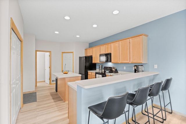 13905 52nd Ave N Unit 701, Plymouth, MN 55446 - kitchen with black appliances, light brown cabinets, a center island, light countertops, and recessed lighting