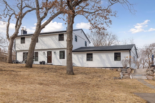 rear view of house featuring a chimney