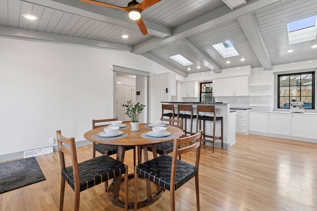 dining room featuring light wood finished floors, recessed lighting, visible vents, lofted ceiling with skylight, and baseboards