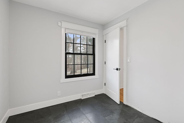 unfurnished room with visible vents and baseboards