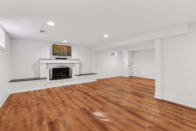 unfurnished living room with recessed lighting, visible vents, a fireplace, and wood finished floors