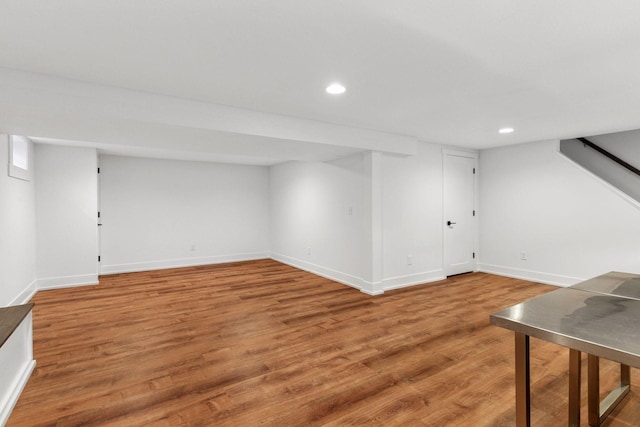 finished below grade area featuring baseboards, wood finished floors, and recessed lighting