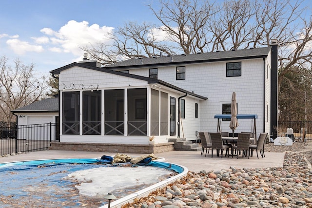 back of property with a patio, a chimney, fence, and a sunroom